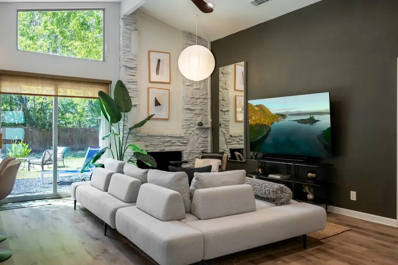 Open living room with vaulted ceiling and large television