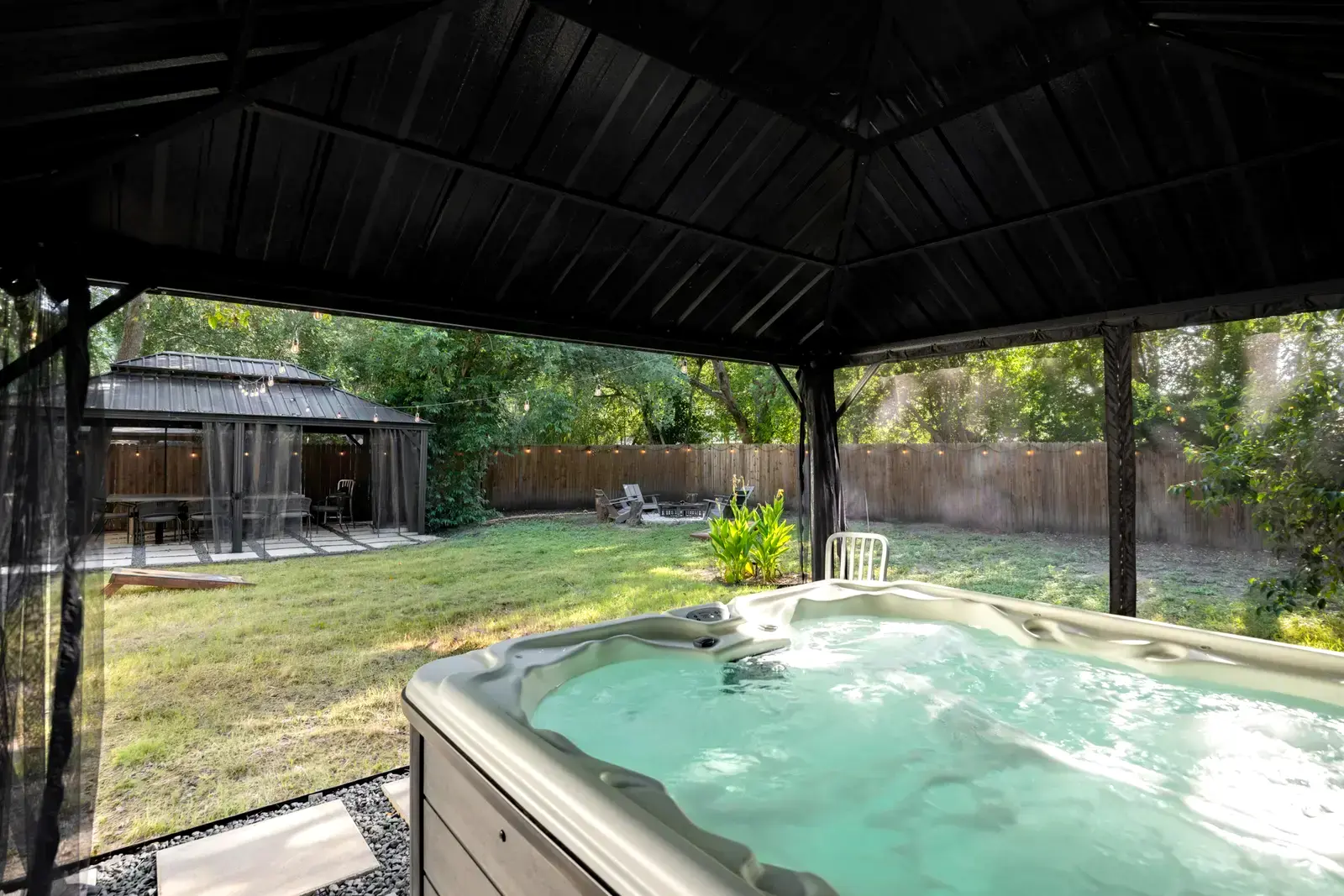 Private covered hot tub looking over the backyard